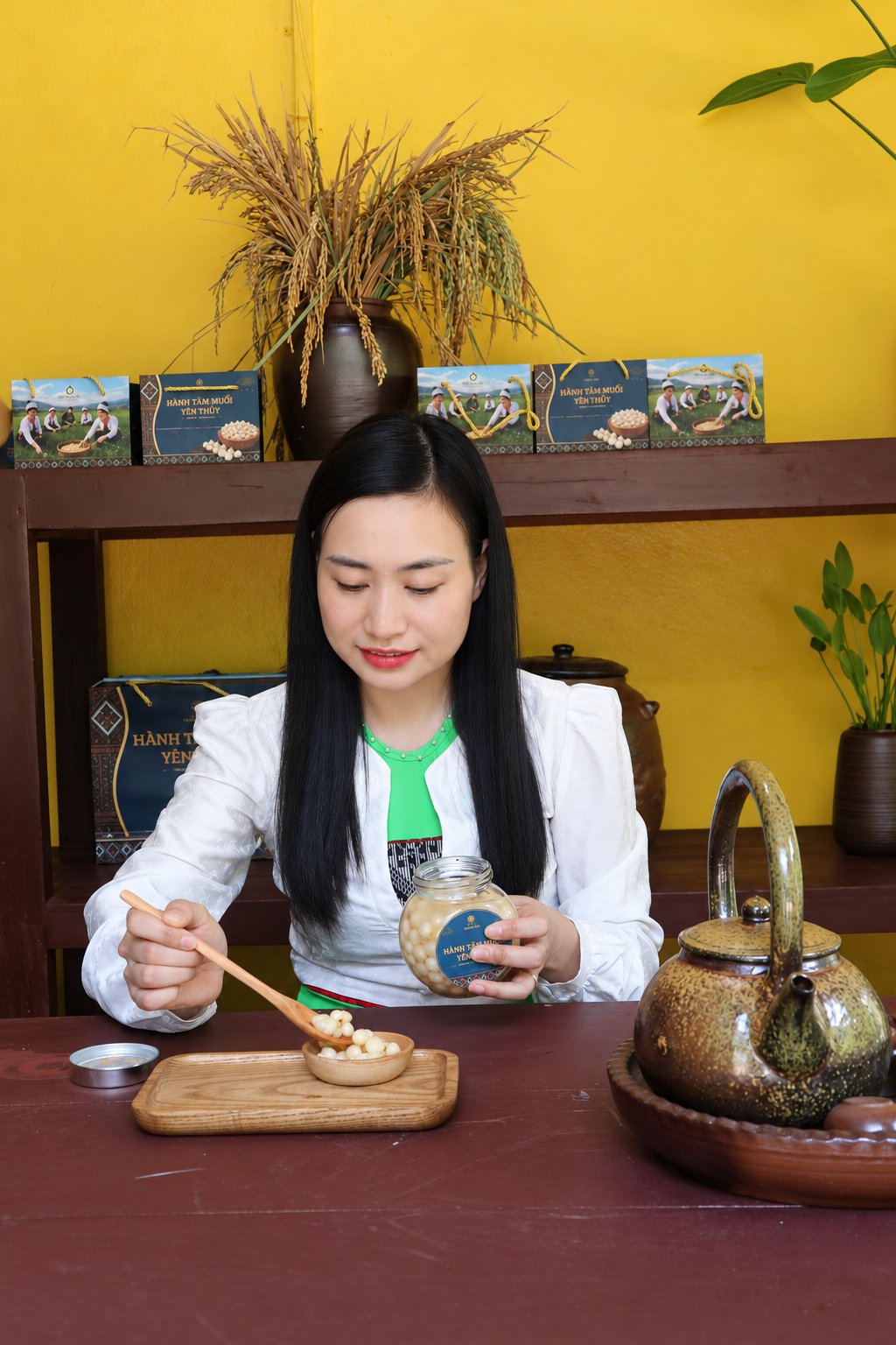 Người phụ nữ Mường Việt múc hành tăm muối từ hũ ra chén gỗ